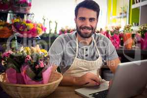 Male florist using laptop at his flower shop