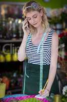 Female florist taking order on mobile phone