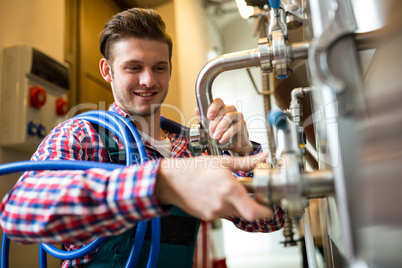 Maintenance workers examining brewery machine