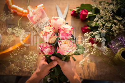 Male florist preparing flower bouquet