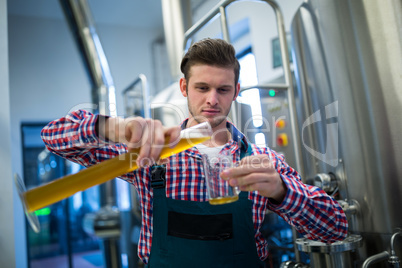 Brewer pouring beer in pint glass