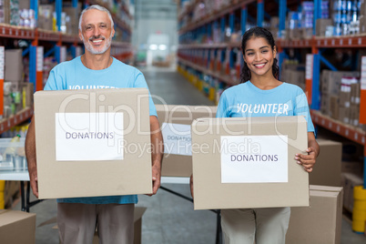 Happy volunteers are smiling and holding donations boxes