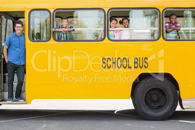 Portrait of teacher and kids looking from bus