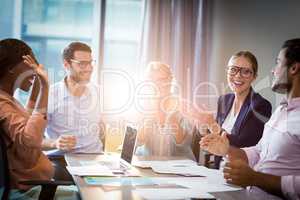 Coworkers applauding a colleague during a meeting