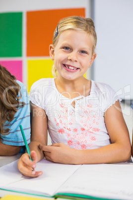 Portrait of schoolgirl drawing in book