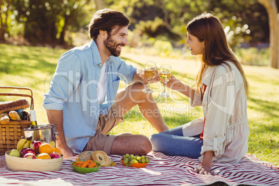 Couple toasting glasses of wine while having breakfast