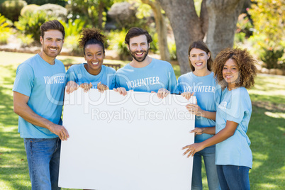 Portrait of volunteer group holding blank sheet Portrait of volunteer group holding blank sheet