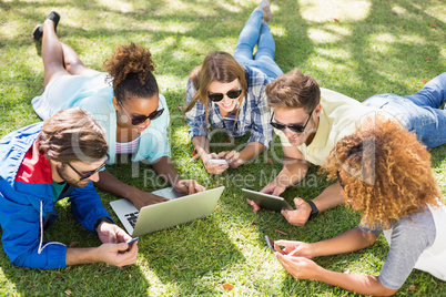 Group of friends using laptop, mobile phone and digital tablet