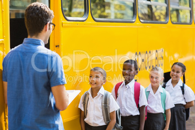 Teacher updating check list of kids