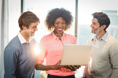 Business people discussing over laptop