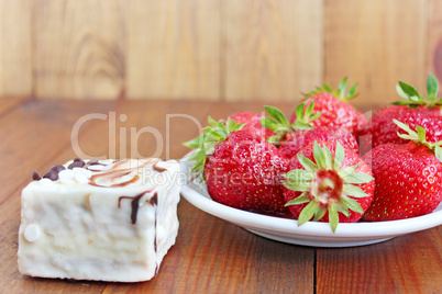 ripe red strawberries on the white plate and cake