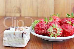 ripe red strawberries on the white plate and cake