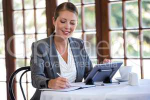 Woman using tablet and notebook