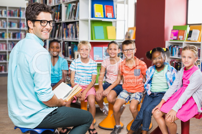 Teacher and kids sitting in library