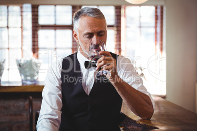 Bartender drinking wine at bar counter