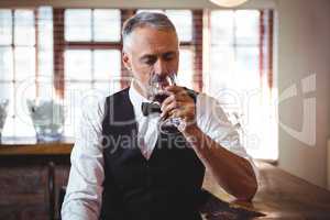 Bartender drinking wine at bar counter