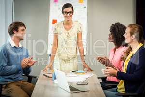 Coworkers applauding a colleague after presentation