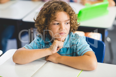 Thoughtful boy looking away while studying