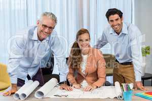 Businesswoman and coworker with blueprint on the desk