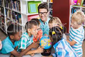 Teacher and kids discussing globe