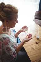 Senior woman looking at her medics in her hands