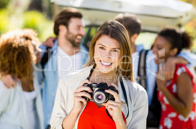 Beautiful woman clicking a photo from camera in park