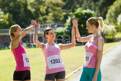 Female athletes giving high five to each other