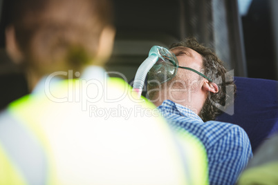 Close-up of an injured man wearing oxygen mask