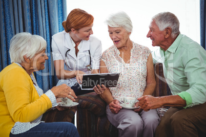 Nurse pointing and showing the screen of a digital tablet to ret