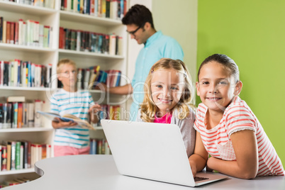 Kids using laptop in library