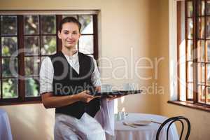 Portrait of smiling waitress holding a tray of coffee cups