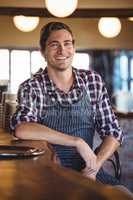 Portrait of waiter sitting at bar counter