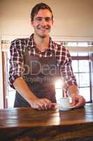 Waiter holding a cup of coffee