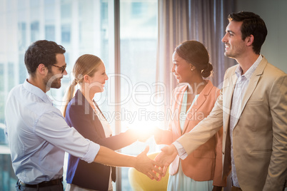 Businessmen and businesswomen shaking hands with each other
