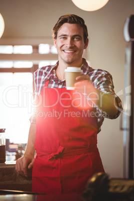 Portrait of waiter offering a cup of coffee