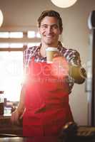 Portrait of waiter offering a cup of coffee