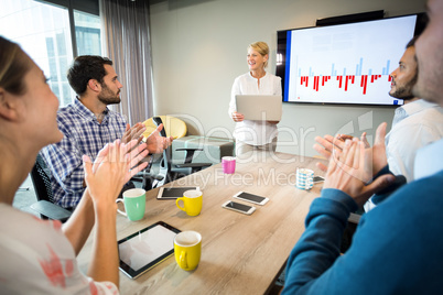 Coworkers applauding a colleague after presentation