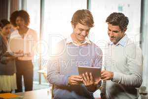 Men working on digital tablet