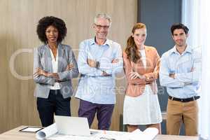 Portrait of smiling business people standing together with arms