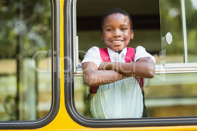 Portrait of schoolboy looking from school bus