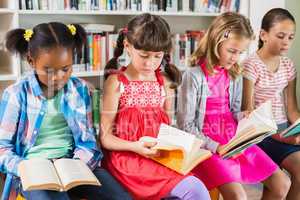 Kids reading a book in library