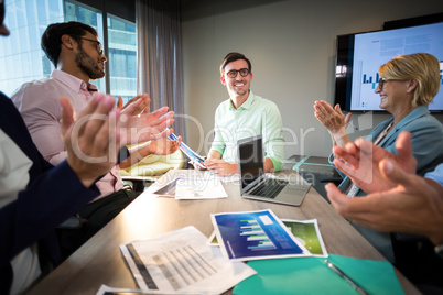 Coworkers applauding a colleague after presentation