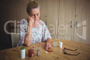 Worried senior woman with medics on the table