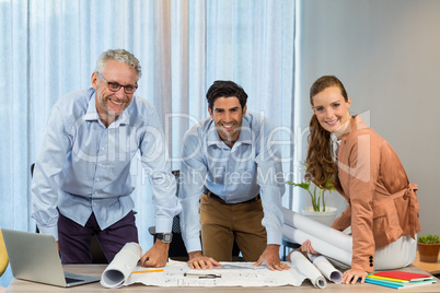 Businesswoman and coworker with blueprint on the desk