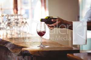Bartender pouring red wine in a glass