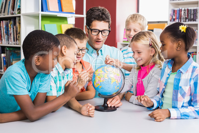 Teacher and kids discussing globe