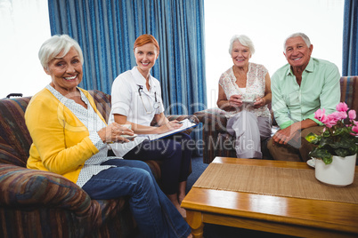 Senior persons and a nurse looking at camera
