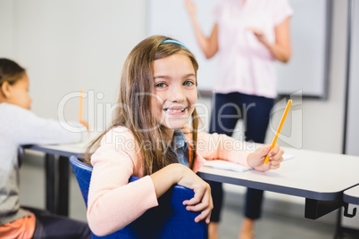 Portrait of schoolgirl smiling in classroom