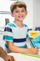 Portrait of schoolboy smiling in classroom