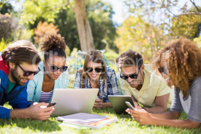 Group of friends using laptop, mobile phone and digital tablet